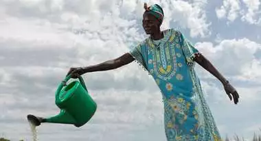 Eine Frau bewässert das Obst und Gemüse in dem schuleigenen Garten, Südsudan 2022.